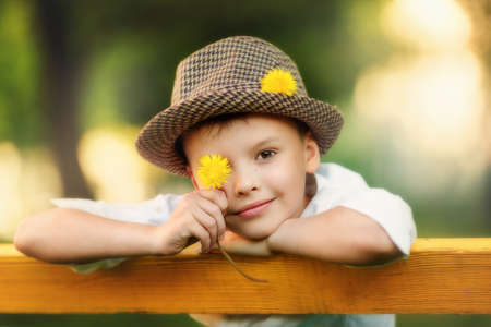 Portrait of happy boy in the hat. Child is smiling in spring day. Kid is enjoying spring. Sunny day....