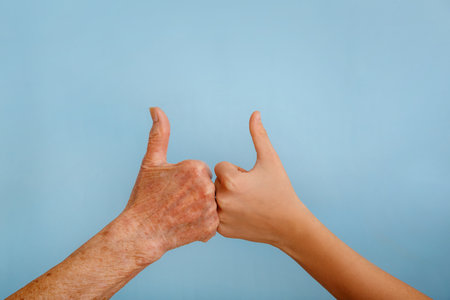 Old and young hands are showing thumb up. Hands gesture positive OK.の写真素材