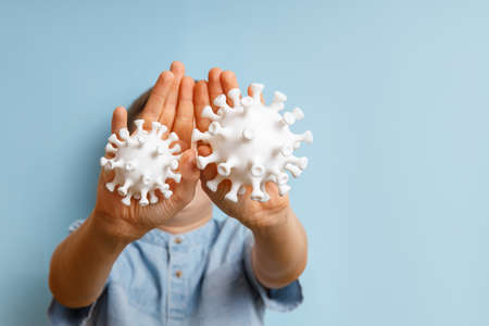 A boy against coronovirus on a blue background. Kid is covering from awful virus and do not let to...