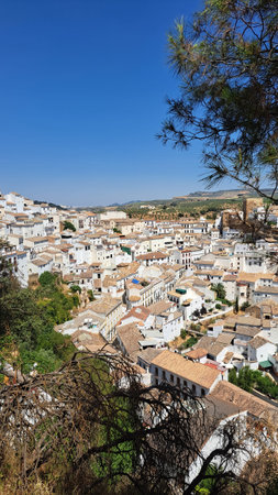 Scenic elevated view of a white Mediterranean town with traditional houses, terracotta tiled roofs and rolling hills in the background. Dense urban texture, warm sunlight and clearの写真素材