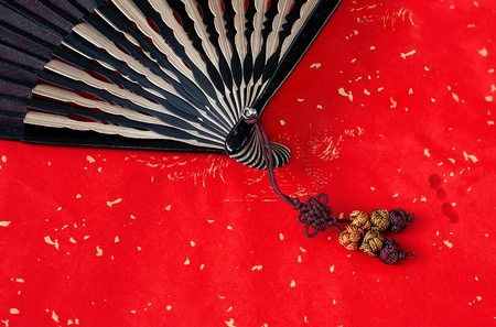 Chinese bamboo fan on red paper backgroundの写真素材