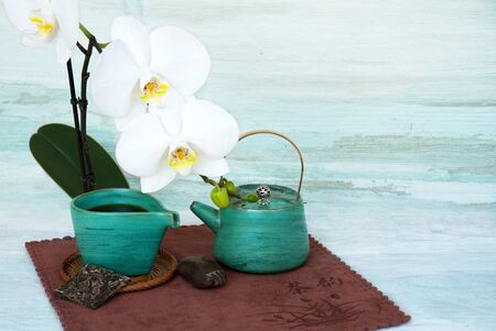Still life with teapot, piece of puer tea  and white orchid flower on abstract backgroundの写真素材