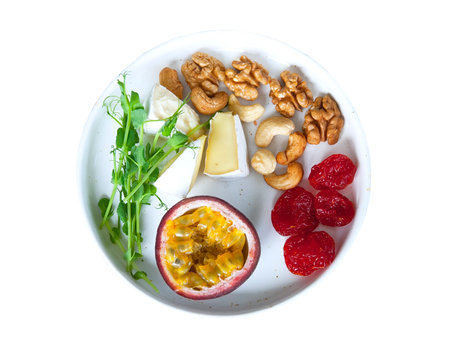 Plate for healthful nutrition with tropical fruits, nuts and greeneryの写真素材
