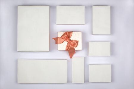 Gift boxes on white background, special gift concept. Beautiful gift box with satin ribbon and bow, color pink bronze. Square boxe. Christmas, New Year, Valentines Day, mothers day, birthday gift.の写真素材