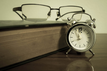 Book, clock and glasses on vintage.