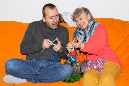 Man learns knitting from his motherの写真素材