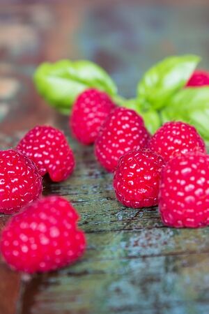 Fresh red raspberries on a colorful wooden table