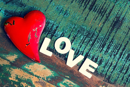 A red heart on a colorful wooden tableの写真素材