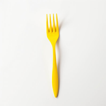 Yellow plastic fork isolated on white background. Minimal food concept.の写真素材