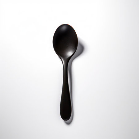 Black spoon on a white background, top view, close-upの写真素材