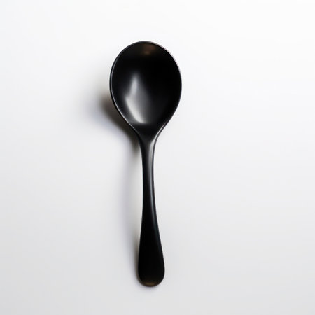 Black plastic spoon isolated on white background. Top view. Flat lay.の写真素材
