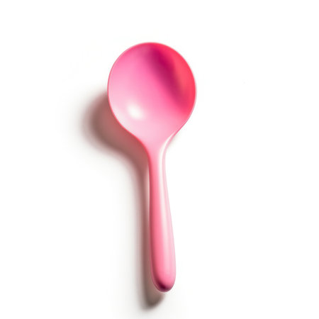 Pink plastic spoon isolated on white background. Top view. Flat lay.の写真素材