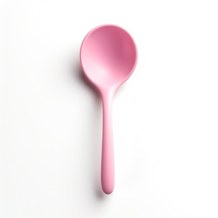 Pink plastic spoon isolated on white background. Top view. Flat lay.の写真素材