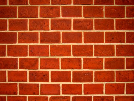 The picture represents a close-up details of a wall with reddish bricks.        