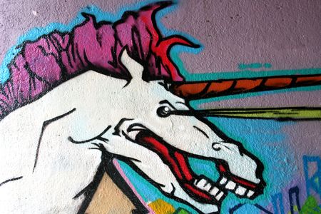 Street art- unicorn abstract graffiti painting on a brick wall.の写真素材