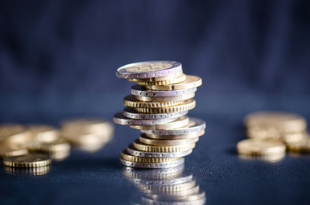 Euro money.Coins are isolated on a dark background with reflection in a glass. Currency of Europe. Balance of money. Building from coins.の写真素材