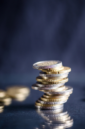 Euro money.Coins are isolated on a dark background with reflection in a glass. Currency of Europe. Balance of money. Building from coins.の写真素材