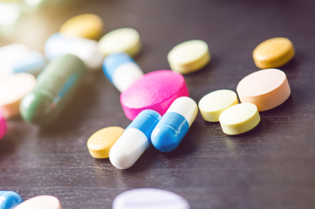Pharmacy background on a black table. Tablets on a black background. Pills. Medicine and Health. Close up of capsules. Differend kind of pillsの写真素材