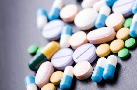 Pharmacy background on a black table. Tablets on a black background. Pills. Medicine and Health. Close up of capsules. Differend kind of pillsの写真素材
