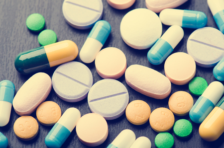 Pharmacy background on a black table. Tablets on a black background. Pills. Medicine and Health. Close up of capsules. Differend kind of pillsの写真素材
