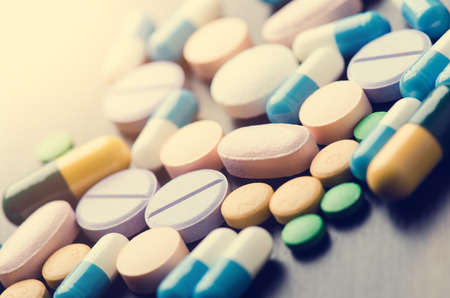 Pharmacy background on a black table. Tablets on a black background. Pills. Medicine and Health. Close up of capsules. Differend kind of pillsの写真素材