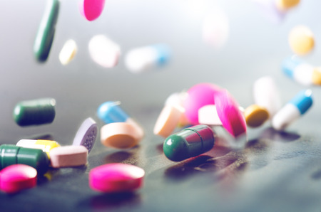 Pharmacy background on a dark table. Levitation pills. Tablets on a dark background Which falling...