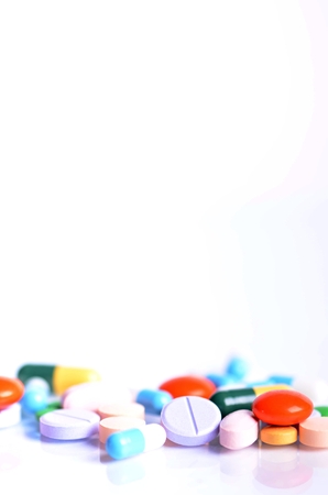 Tablets isolated on a white background. Reflection of pills on a glass. Medicine's background. Pharmacy. Close up of capsules.の写真素材