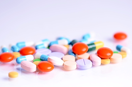 Tablets isolated on a white background. Reflection of pills on a glass. Medicine's background. Pharmacy. Close up of capsules.の写真素材