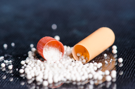 Scattered capsule. Pharmacy background on a black table. Tablets on a black background. Pills. Medicine and Health. Close up of capsules. Differend kind of pillsの写真素材
