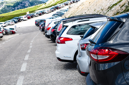 Cars in a parking lot in a middle of mountains. Vehicles on a beautiful sunshine. Transportation backgroundの写真素材