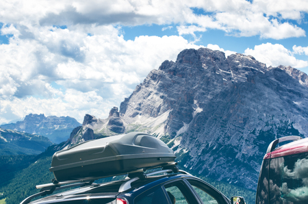 Cars in a parking lot in a middle of mountains. Vehicles on a beautiful sunshine. Transportation backgroundの写真素材