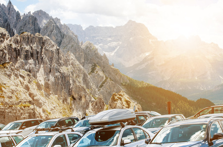 Cars in a parking lot in a middle of mountains. Vehicles on a beautiful sunshine. Transportation backgroundの写真素材
