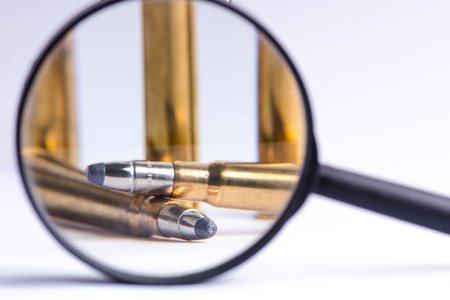 Ammunition on a white background. View through a magnifier. Isolated. Close up. Weapons. Bulletsの写真素材
