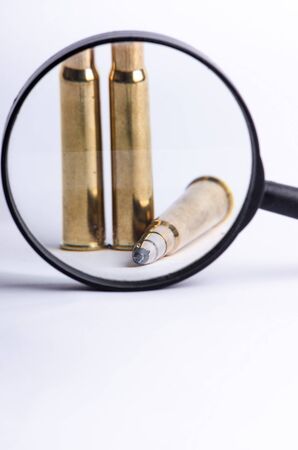 Ammunition on a white background. View through a magnifier. Isolated. Close up. Weapons. Bulletsの写真素材