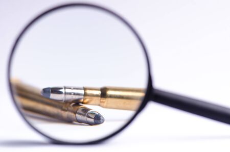 Ammunition on a white background. View through a magnifier. Isolated. Close up. Weapons. Bulletsの写真素材