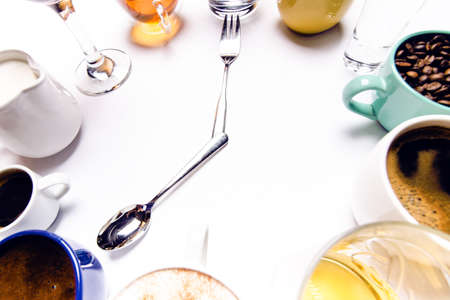 Cups with liquids like a coffee, milk, wine, alcohol, juice stacked in a circle. Clock consist of twelve cups. Time. Alarm clock. Beverages.の写真素材