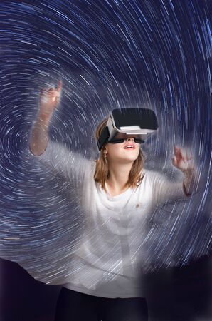 Double exposure. Woman with virtual reality goggles lie on a carpet. Studio Woman show a gesture.の写真素材