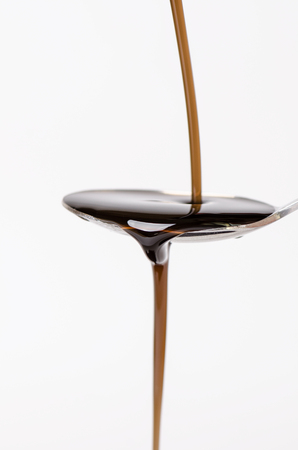 pouring a liquid on a spoon. Natural green background. Pharmacy and healthy background. Medicine. Cough and cold drug.の写真素材