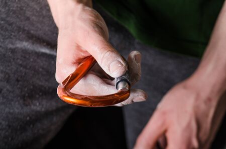 ManÂ´s hand holding a carabine on a rope. Climbing equipment isolated on a white background. Hand in powder chalk magnesium.の写真素材