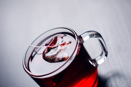 Cup of hot tea with teabag. On a natural, dark background. Cup is from clear glass.の写真素材