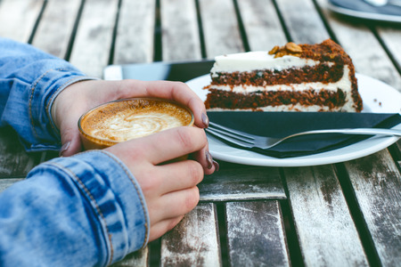 Coffee mug and cake on a wooden vintage table. Hipster concept. Woman drink a coffee. Cups of americano and macchiato.の写真素材
