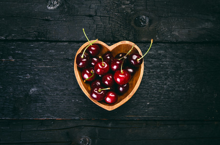 Cherries on a black table.. Natural wooden burnt table. Fresh food concept. Fruit. Summer timeの写真素材