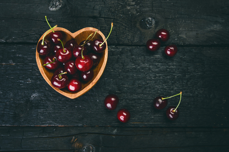 Cherries on a black table.. Natural wooden burnt table. Fresh food concept. Fruit. Summer timeの写真素材
