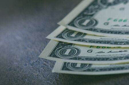 One dollar banknotes on a black table with credit cards. Cash money american dollars. Vintage background. Lens flare. American currency. Internet bankingの写真素材