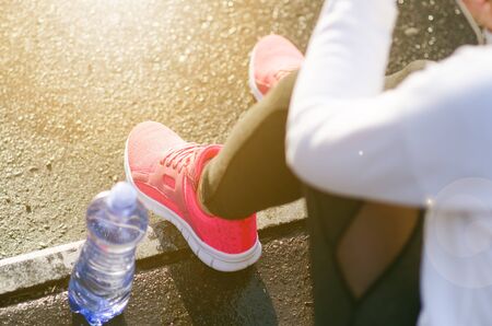 Close up of womanÂ´s sports shoes. Young woman have a rest on stairs. Healthy lifestyle. Fitness...