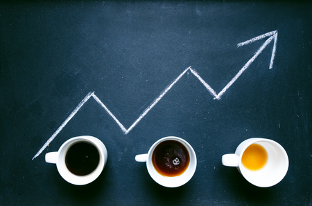 Coffee and arrow from coffee beans. Move up of energy. Trend up of energy. Arrow and graph. Coffee on a blackboard. Concept of energyの写真素材
