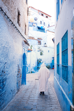 Muslim man in tradition maroccan dress walking in blue city called - Chefchaouen.の写真素材