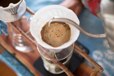 barista pouring hot water on coffee ground, home brewing processの写真素材