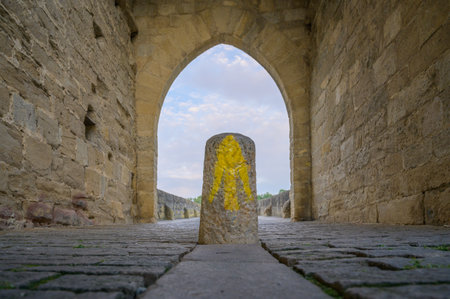 Way marking with yellow arrow symbol sign on St. James Pilgrimage route in Puente la Reina, Navarraの写真素材