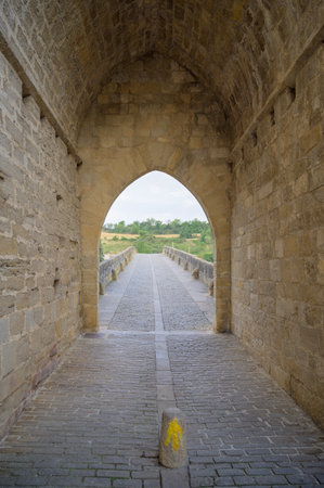 Way marking with yellow arrow symbol sign on St. James Pilgrimage route in Puente la Reina, Navarraの写真素材